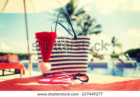summer holidays, christmas and vacation concept - santa helper hat, bag, sunscreen and sunglasses