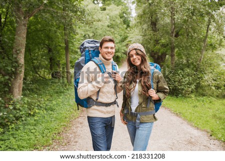 adventure, travel, tourism, hike and people concept - smiling couple with backpacks outdoors