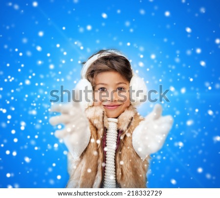 winter, christmas, childhood, happiness and people concept - smiling little girl in winter clothes