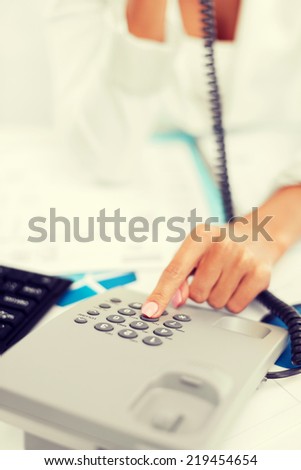 business, communication and helpline concept - businesswoman with phone calling or dialing the number