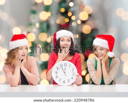 winter, holidays, time and people concept - smiling women in santa helper hats with clock over christmas tree background