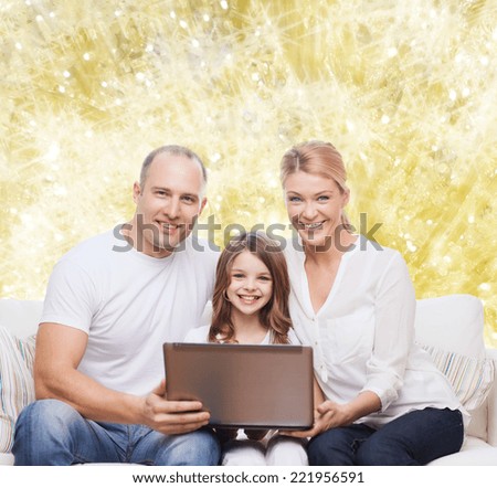family, childhood, holidays, technology and people concept - smiling family with laptop computer over golden lights background