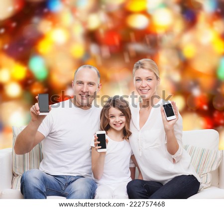 holidays, technology, advertisement and people concept - smiling family with smartphones over red lights background