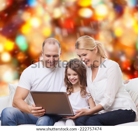 family, childhood, holidays, technology and people concept - smiling family with laptop computer over red lights background