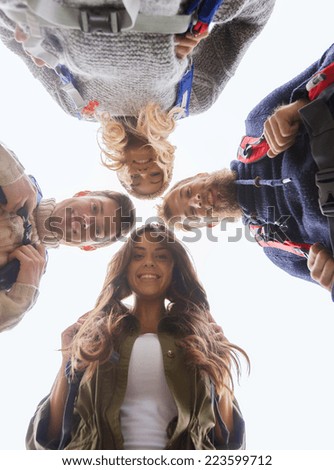 adventure, travel, tourism, hike and people concept - group of smiling friends with backpacks standing in circle outdoors