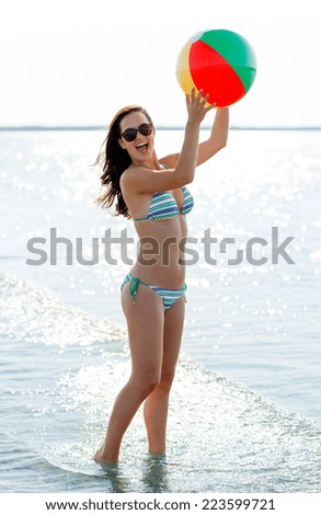 sea, summer vacation, holidays, sport and people concept - smiling teenage girl in sunglasses with inflatable ball on beach