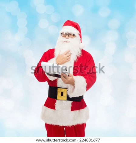 christmas, holidays and people concept - man in costume of santa claus with notepad over blue lights background
