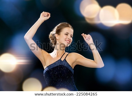 people, party, holidays and glamour concept - smiling woman dancing with raised hands over night lights background