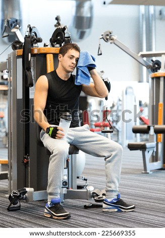 sport, fitness, equipment, lifestyle and people concept - man exercising on gym machine
