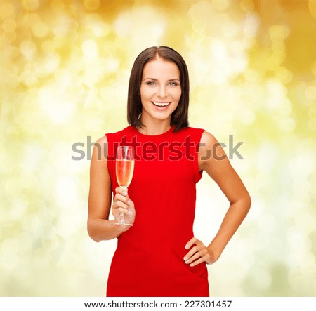 party, drinks, holidays, christmas and celebration concept - smiling woman in red dress with glass of sparkling wine over yellow lights background