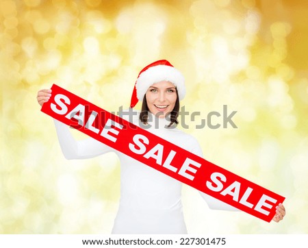 sale, shopping, christmas, holidays and people concept - smiling woman in santa helper hat with red sale sign over yellow lights background