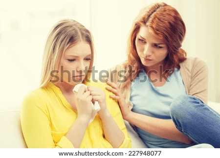 friendship and people concept - one teenage girl comforting another after break up