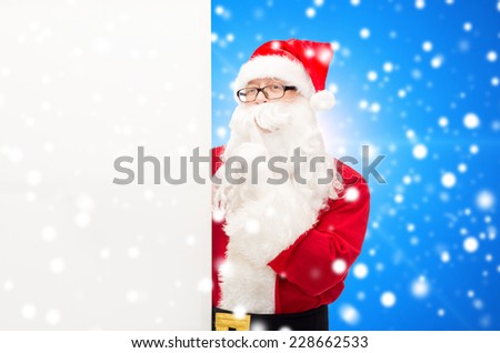 christmas, holidays, advertisement and people concept - man in costume of santa claus with white blank billboard making hush gesture over blue snowy background