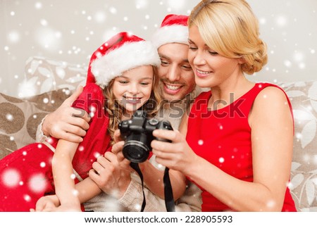 christmas, holidays, technology and people concept - happy family with digital camera watching photos at home