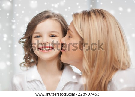 people, motherhood, family, winter and adoption concept - happy mother and daughter cuddling at home
