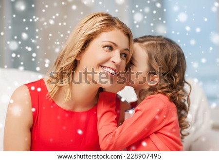 people, motherhood, family, winter and adoption concept - happy mother and daughter whispering something into ear at home