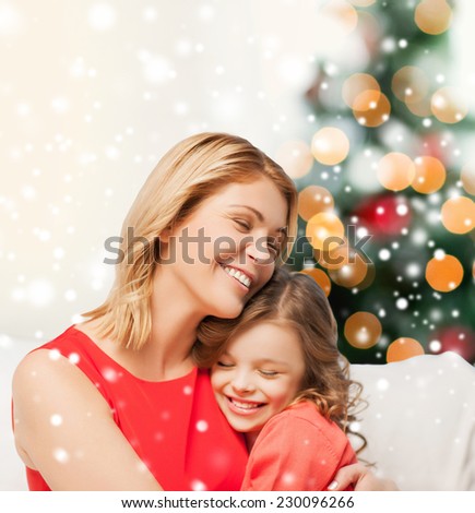 people, motherhood, family, christmas and adoption concept - happy mother and daughter hugging at home