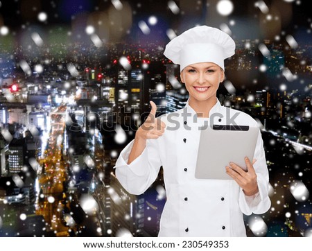 cooking, holidays, technology and people concept - smiling female chef, cook or baker with tablet pc computer showing thumbs up over snowy night city background