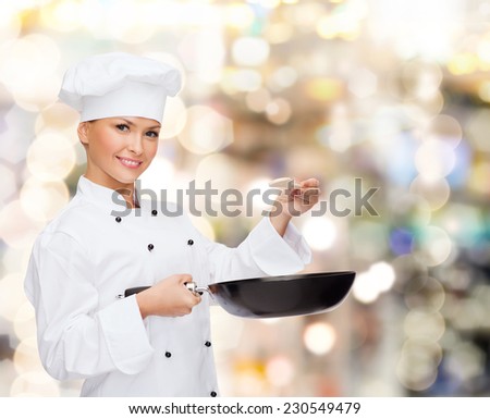 cooking, holidays, people and food concept - smiling female chef with pan and spoon tasting food over lights background