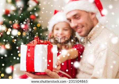 christmas, holidays, family and people concept - smiling father and daughter holding gift box and hugging at home