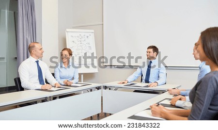 business, people and teamwork concept - group of smiling businesspeople meeting in office