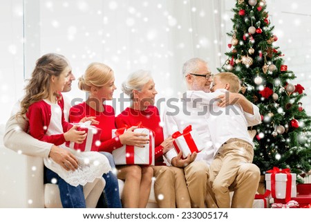 family, holidays, generation, christmas and people concept - smiling family with gift boxes sitting on couch and hugging at home