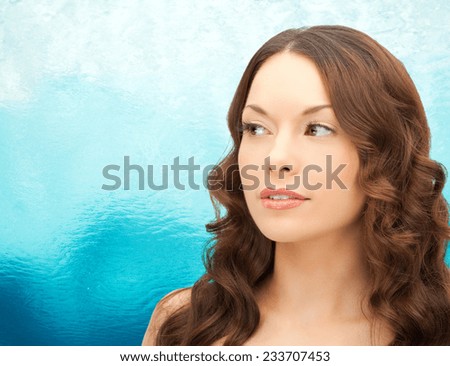 beauty, people and health concept - beautiful young woman face over ripple blue water background
