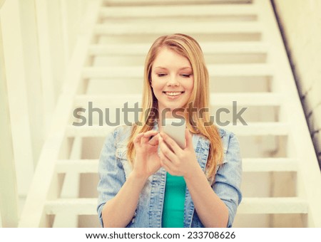 education and technology concept - smiling female student with smartphone sitting on staircase