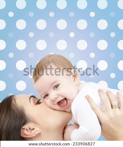 motherhood, children, adoption, happiness and people concept - happy mother kissing her baby boy over blue and white polka dots pattern background
