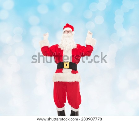 christmas, holidays and people concept - man in costume of santa claus having fun over blue lights background