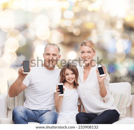 holidays, technology, advertisement and people concept - smiling family with smartphones over lights background