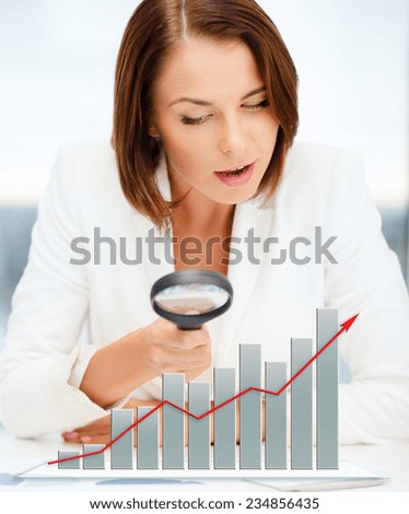 business, documents, statistics and people concept - businesswoman looking through magnifier to graphs in office