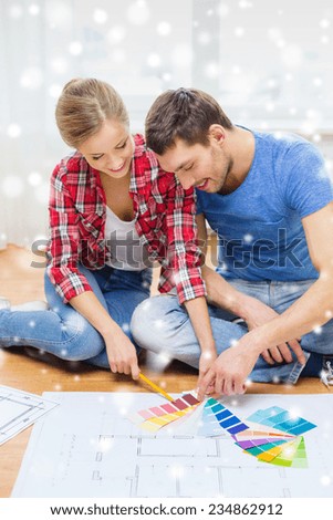 repair, interior design, building, renovation and people concept - smiling couple selecting color from samples at home