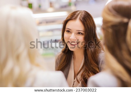 communication, friendship and people concept - happy young women meeting and talking in mall or city