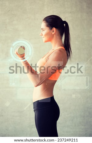 fitness, sport, training, future technology and lifestyle concept - smiling woman with dumbbells in gym and projections