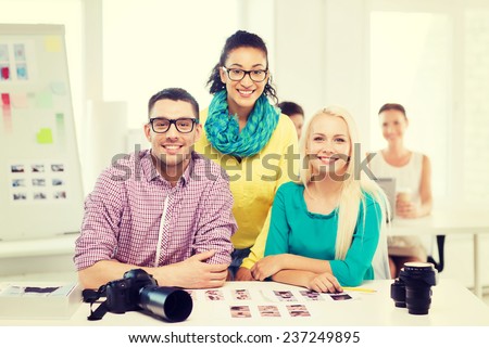 business, education, photography, office and startup concept - smiling creative team with printed photos working in office