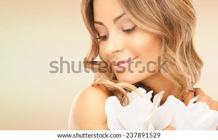 beauty, people and health concept - beautiful young woman with flowers and bare shoulders over pink background