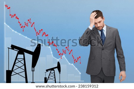 business, people, crisis, finances and economics concept - businessman with forex chart and pumpjacks touching his head over blue background