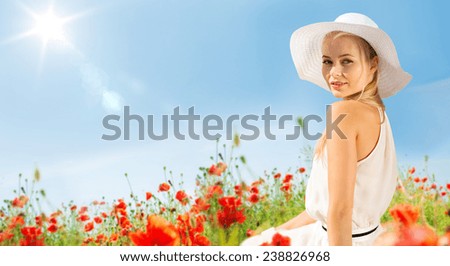 happiness, nature, summer, vacation and people concept - smiling young woman with closed eyes wearing straw hat on poppy field