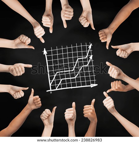 gesture, people, business and development concept - human hands showing thumbs up in circle over black board background with graph