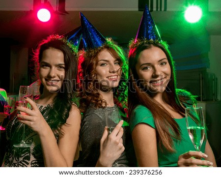 party, holidays, celebration, nightlife and people concept - smiling friends with glasses of champagne in club