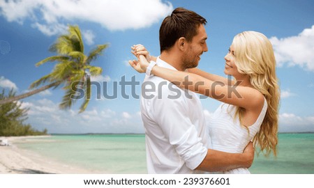 summer holidays, people, love, travel and dating concept - happy couple hugging over tropical beach background