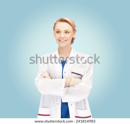 medicine, people, profession and healthcare concept - smiling young female doctor in white coat over blue background