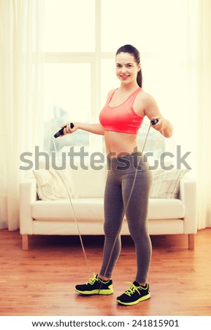 fitness, home and diet concept - smiling teenage girl with skipping rope at home