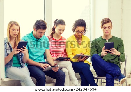 education and technology concept - smiling students with tablet pc computer at school