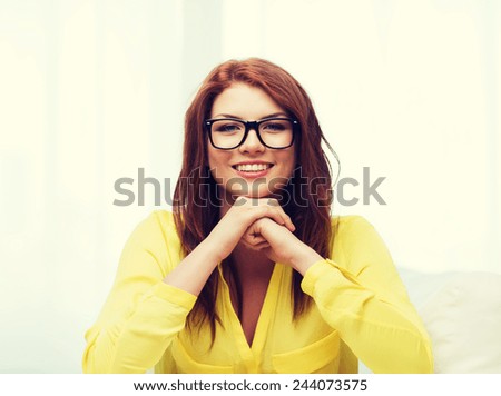 education, people and happiness concept - smiling teenage girl in eyeglasses at home