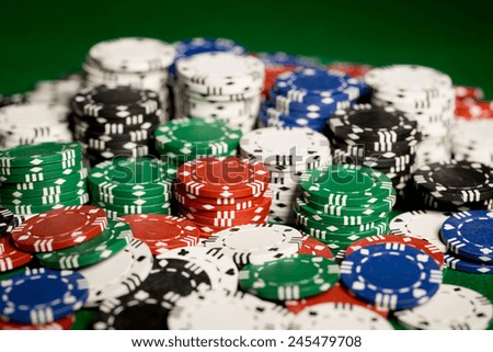 gambling, fortune, game and entertainment concept - close up of casino chips on green table surface