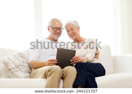 family, technology, age and people concept - happy senior couple with tablet pc computer at home