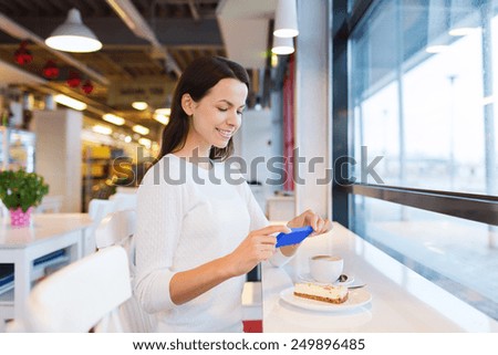 drinks, food, people, technology and lifestyle concept - smiling young woman taking picture with smartphone and drinking coffee at cafe