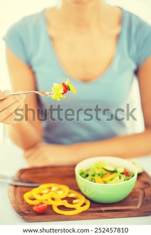 healthy food and kitchen concept - woman hand holding fork with vegetables